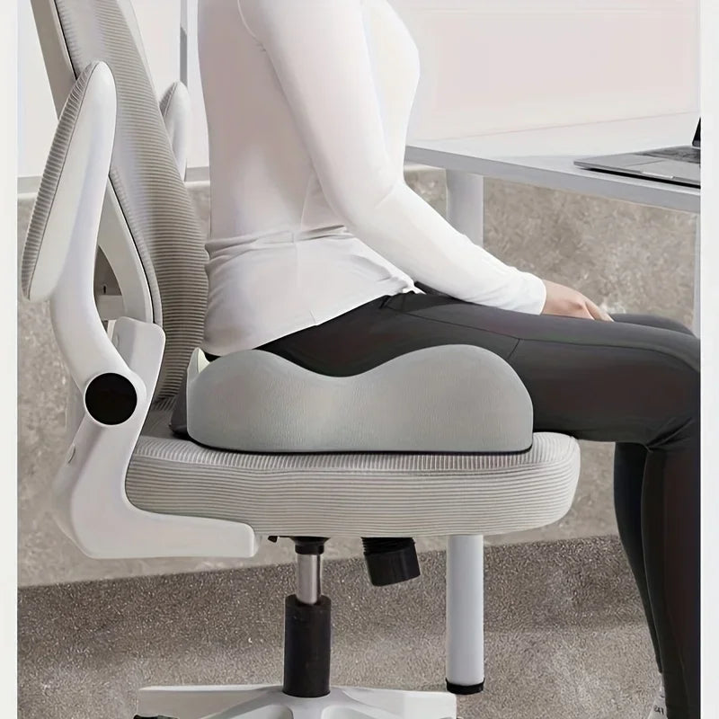 Woman sitting at her desk on the grey Easely ergonomic seat cushion